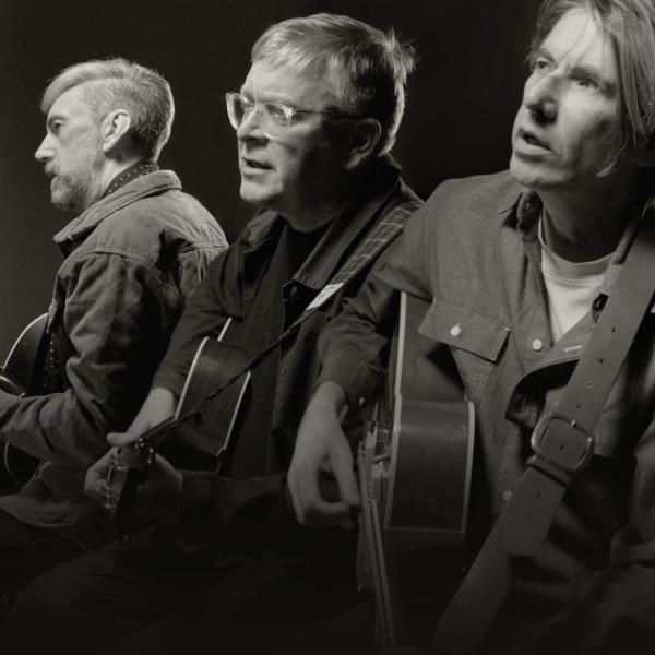 Black and white image of Norman Blake, Bernard Butler and James Grant playing guitars and singing.