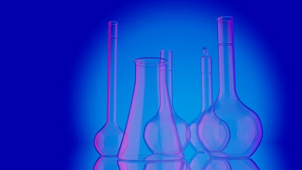 A picture of several pieces of glass chemistry lab equipment on a blue background 