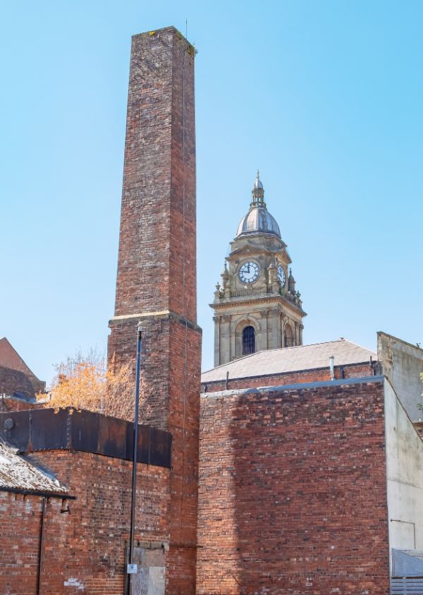 A photograph of Morley Town Hall clock behind a chimney. 