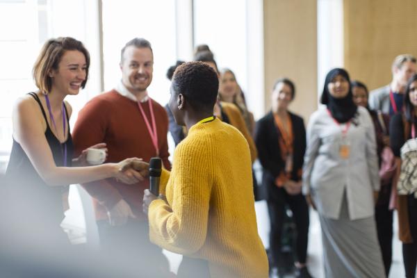 businesswoman-shaking-hands-with-speaker-at-conference