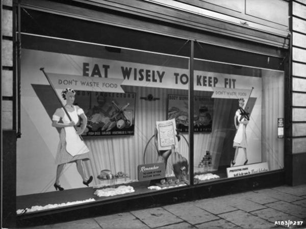 A black and white image of a department store window in Leeds (Lewis's), with a wartime display on how to 'Eat Wisely To Keep Fit'