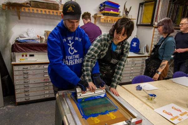 Pyramid artist working with facilitator to create a screen print at Leeds Print Workshop