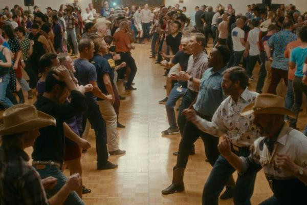 A large group of people face each other in a line dance