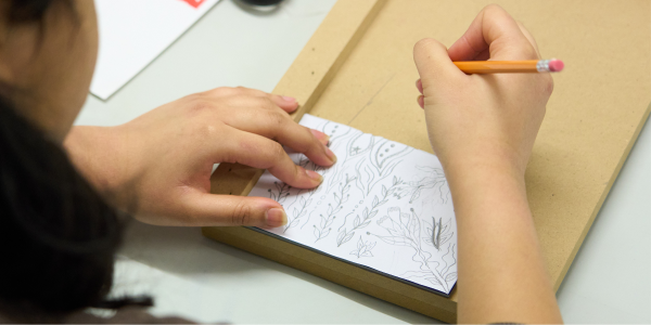 Woman drawing sketch to be carved, line picture with pencil 