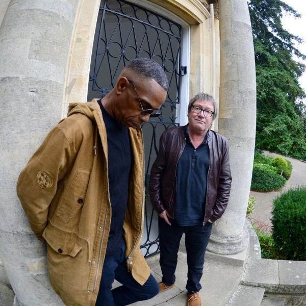 Simon Fowler and Oscar Harrison of Ocean Colour Scheme stood in front of an old-looking iron door.