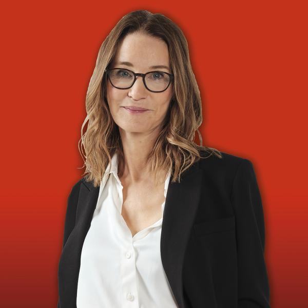 Susie Dent wearing a black suit jacket and white blouse.