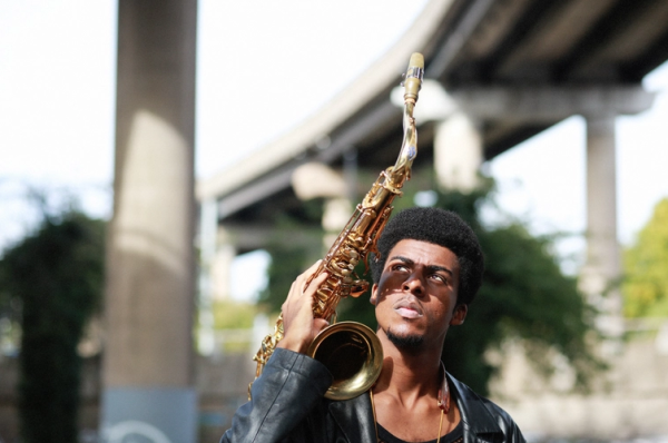 Xhosa Cole holding saxophone