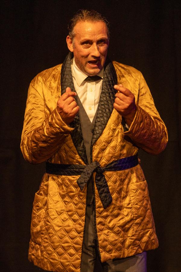 Actor playing Sherlock Holmes stood in a gold jacket.