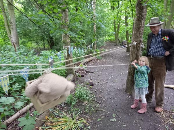 Photo of a little girl playing in the woods with her grandfather