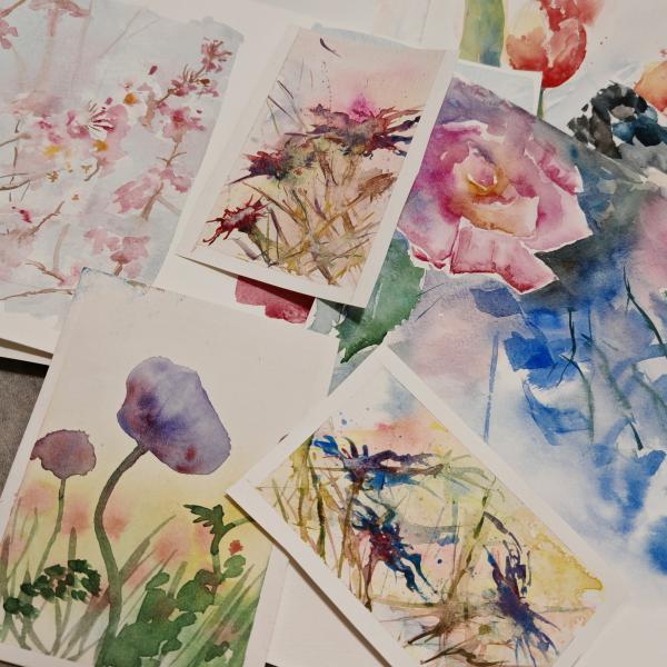 A selection of watercolour paintings of flowers in various colours