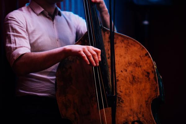 Close up of a man standing playing double bass.