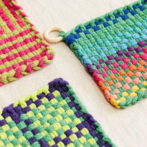 Image shows three colourful woven pot holders / coasters.
