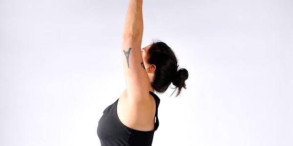 Yoga Teacher Amy in a Warrior pose with her arms lifted