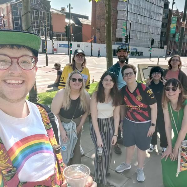 A groups stand in the sunshine smiling at the camera