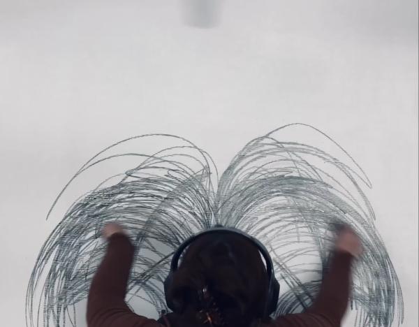 A person wearing headphones draws in expressive arcs.
