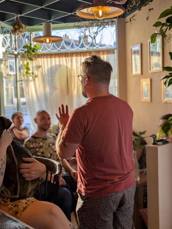 A storyteller stands in front of a group of people. 