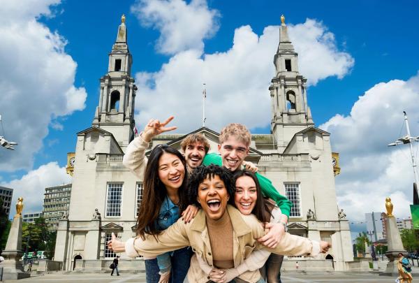 Group of friends smiling in front of city council building