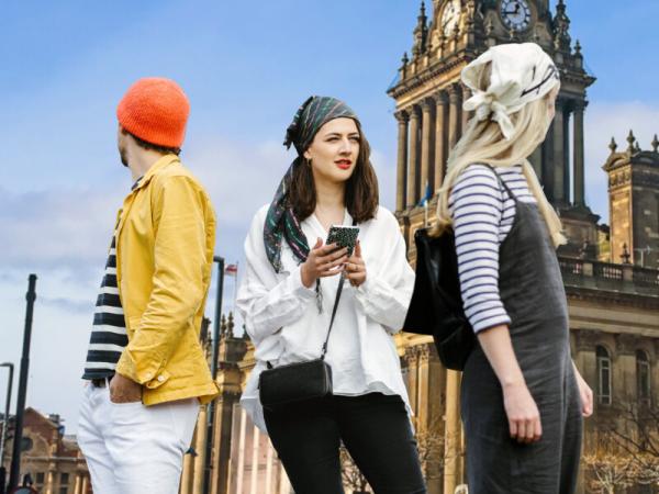 Three people hunting for clues on Treasure Hunt Leeds outside Leeds Town Hall
