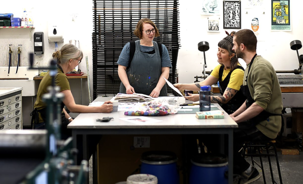 A group of people at a table in an art studio