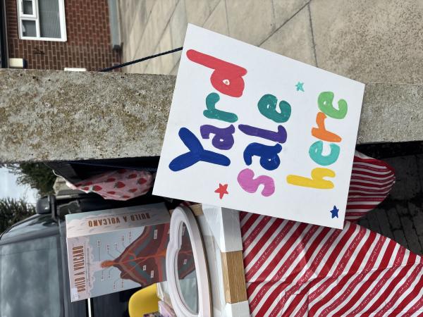 image shows stall at a yard sale with a sign saying 'Yard Sale Here'