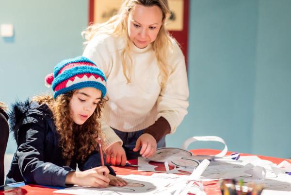 A woman and a young girl taking part in arts and crafts.