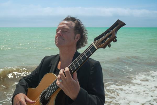 Richard Durrant with his bog oak guitar by the sea