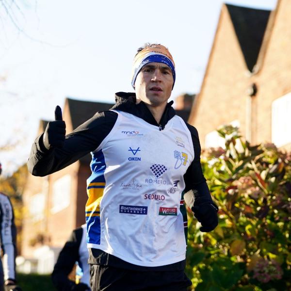 Kevin Sinfield running wearing a Leeds Rhinos hat.