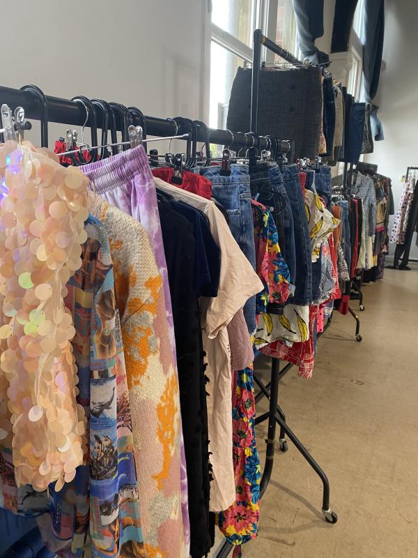 Rails of colourful clothing in a brightly lit room