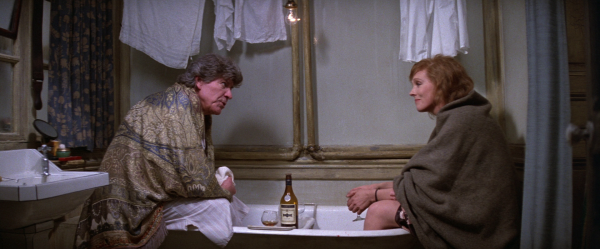 Robert Preston and Julie Andrews wrapped in blankets sat in a bath sharing a bottle of wine