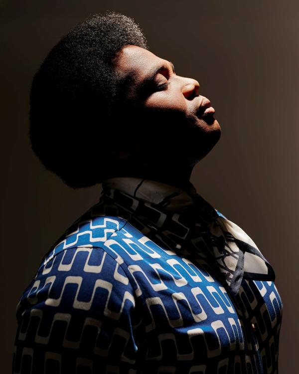 Man in profile with blue shirt and contemplative expression