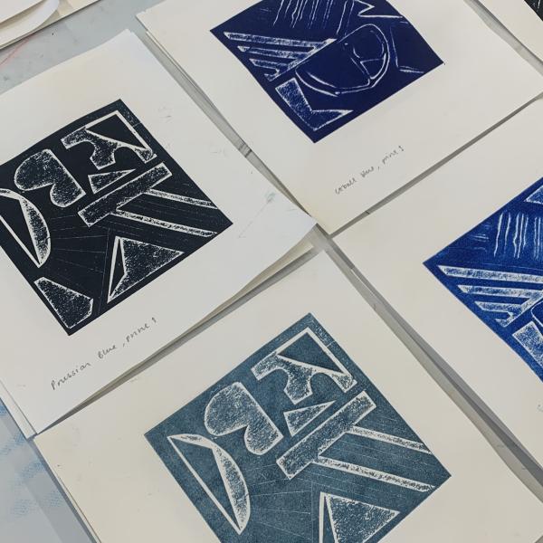 A photograph of 4 collagraph prints laying on a table
