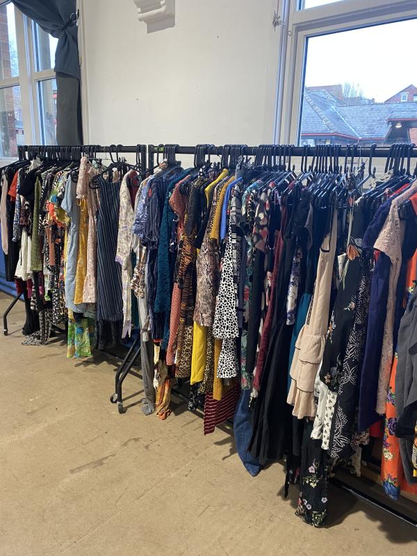 Rails of colourful clothing in a brightly lit room