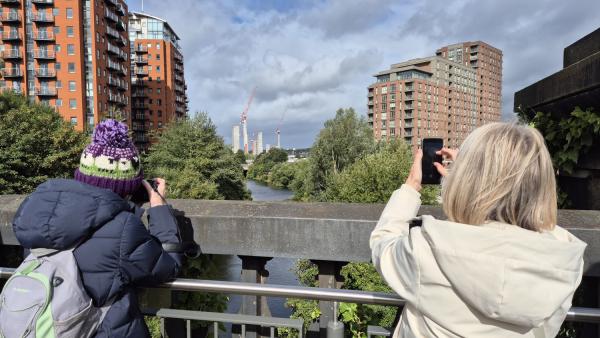 A photograph of two people taking photographs on a bridge in Holbeck