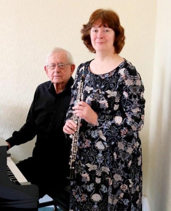 Lady with a clarinet and a man sat at the piano
