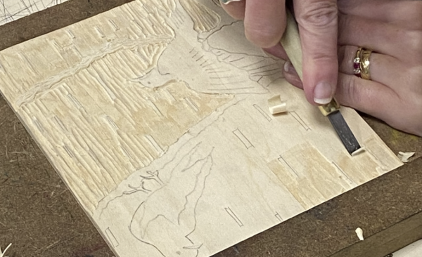 An image of birds being carved in to a wood plate to be printed from