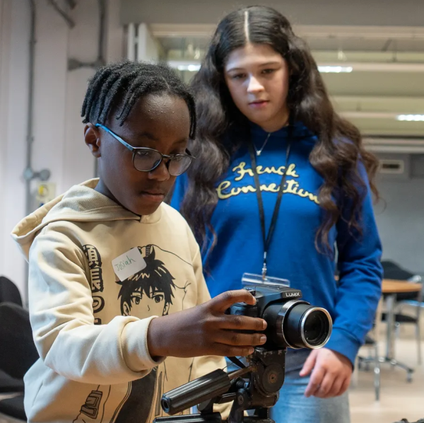 Child using a camera in filmmaking workshop