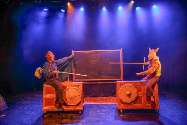 Two loopy professors jousting on wooden boxes with mops