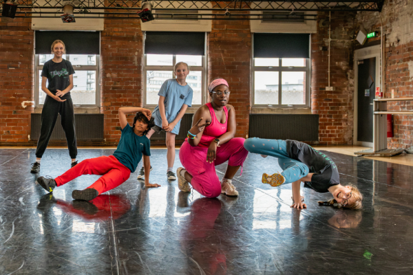 A group of children are in different street dance poses in a dance studio
