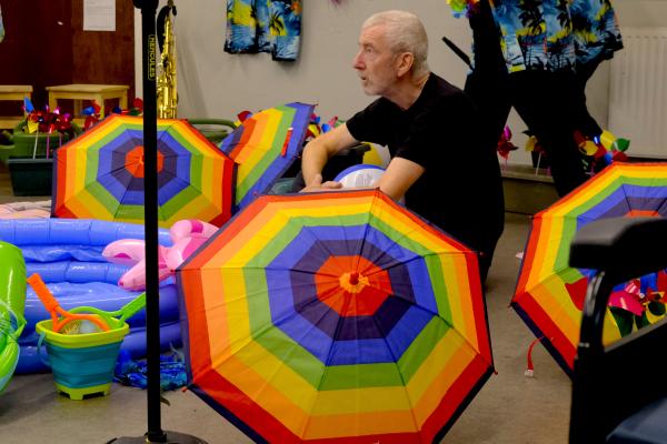 John Poulter in rehearsal with rainbow umbrellas with The Performance Ensemble