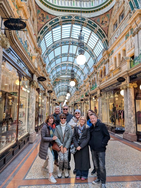 Tour guests inside a shopping arcade that is decorated in ornate Victorian style