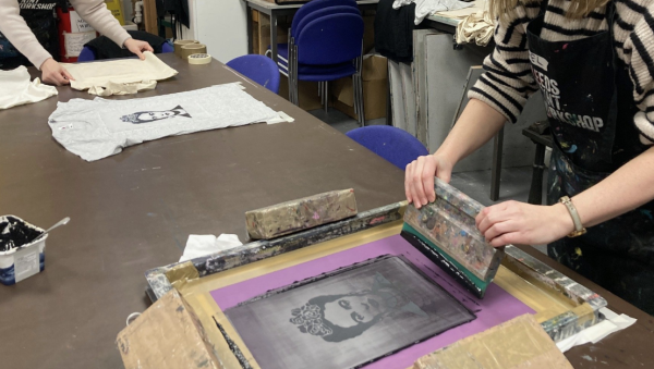 A black and white image of Frida Kahlo being screen printed onto a t-shirt