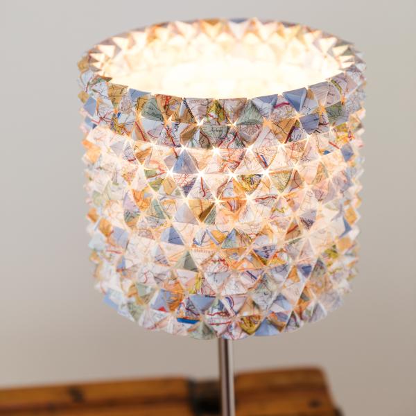A photograph of a sculptural lampshade made from OS maps.