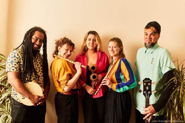 A group of musicians stand together with their instruments