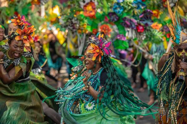 Green costumed dancers smiling in Carnival attire
