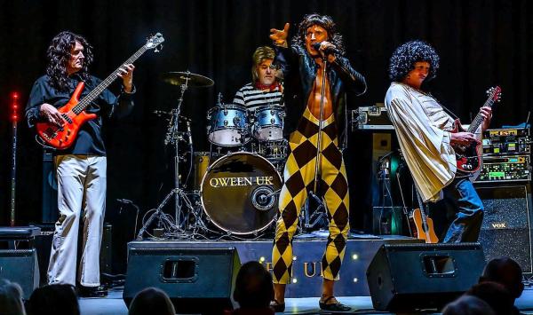 Four piece Queen tribute band dressed in various leotards, capes and wigs, playing bass, drums and guitar, it all looks rather splendid fun!