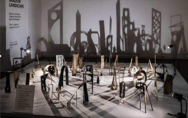 Lots of small sculptures on the floor lit to make strong shadow-shapes 