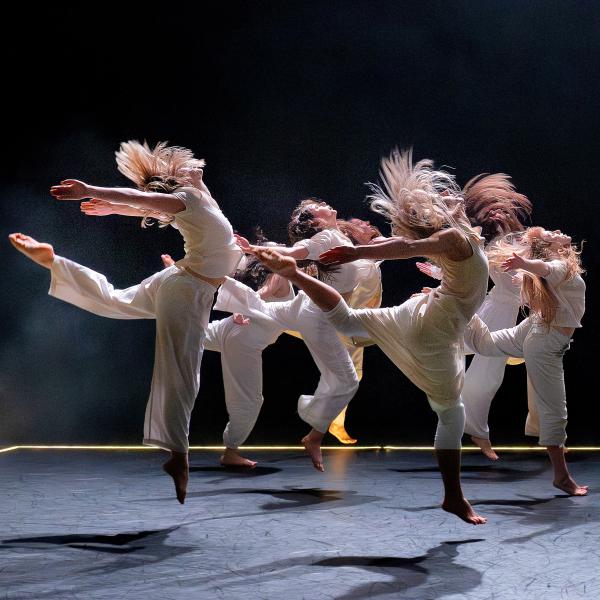 Dancers on stage jump in the air