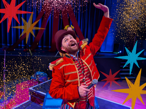 Mr Montgomery is in the centre of the image, wearing a circus, ring-master style red jacket with gold trim and a top hat, holding a microphone and looking upwards mid-song. He is surrounded by colorful hand-drawn style stars and sparkling confetti against a dark and colourful lit stage.
