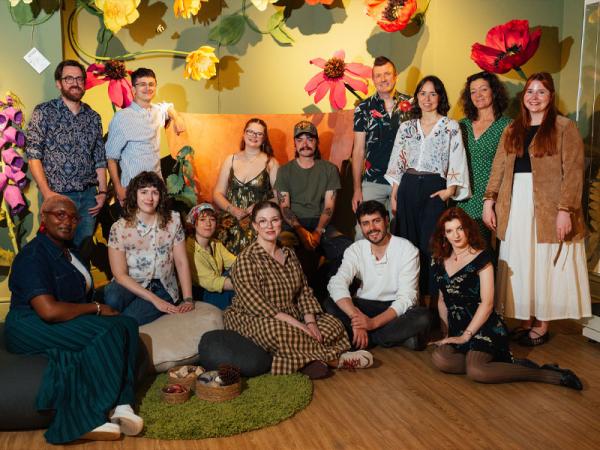 Group of people in a museum exhibition space, all smiling at the camera.