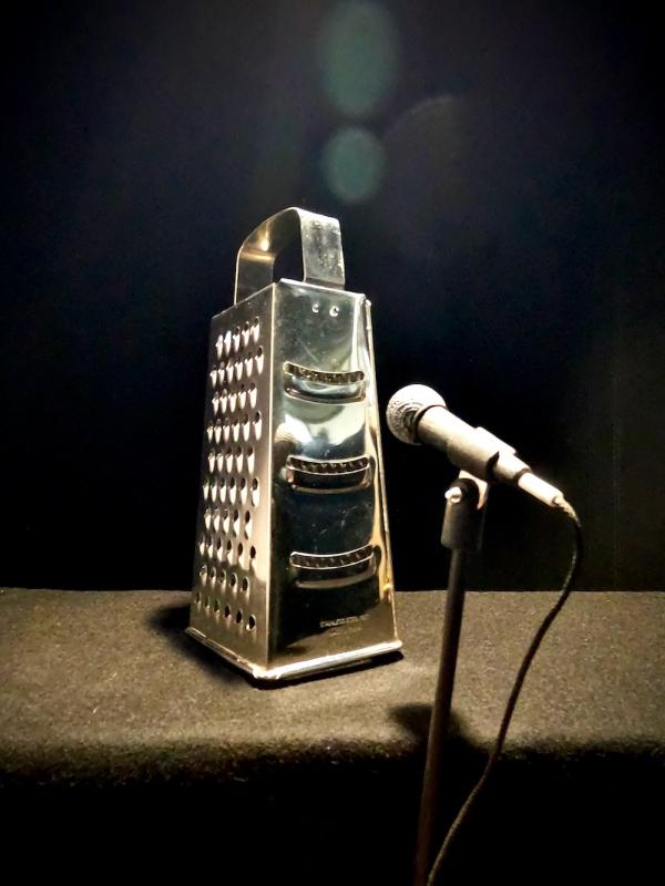 A cheese grater infront of a microphone